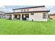 Large backyard with well-maintained green lawn, covered patio, and home exterior with a red tile roof at 3833 Bowfin Trl, Kissimmee, FL 34746
