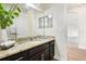 Bathroom showcasing granite countertops, dark cabinetry, a large mirror, and decorative accents at 3833 Bowfin Trl, Kissimmee, FL 34746