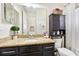 Bathroom showcasing granite countertops, dark cabinetry, a large mirror, and decorative accents at 3833 Bowfin Trl, Kissimmee, FL 34746