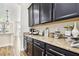 Beautiful coffee bar featuring dark cabinets, granite countertops, and stylish decor at 3833 Bowfin Trl, Kissimmee, FL 34746