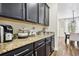 Charming coffee bar with dark cabinets, granite countertop, and decorative accessories at 3833 Bowfin Trl, Kissimmee, FL 34746
