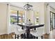 Cozy dining area featuring a contemporary chandelier, modern furniture, and a view of the landscaped backyard at 3833 Bowfin Trl, Kissimmee, FL 34746