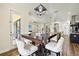 Stylish dining area with a modern chandelier, comfortable seating, and easy access to kitchen and backyard at 3833 Bowfin Trl, Kissimmee, FL 34746