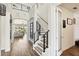Spacious foyer with wood-look tile flooring, two-story ceilings, and a modern wrought iron staircase at 3833 Bowfin Trl, Kissimmee, FL 34746
