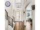 Bright and airy foyer featuring wood-look tile flooring, soaring ceilings, and wrought iron stair railing at 3833 Bowfin Trl, Kissimmee, FL 34746