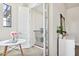 Bright hallway featuring white walls, modern table, and a glimpse of the staircase through an open doorway at 3833 Bowfin Trl, Kissimmee, FL 34746