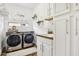 Well-equipped laundry room features modern washer and dryer, ample storage, and stylish decor at 3833 Bowfin Trl, Kissimmee, FL 34746