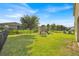 Large backyard featuring lush green grass, black fencing, and a playground at 3853 Cortland Dr, Davenport, FL 33837