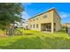 View of the home's back exterior and expansive backyard with well-maintained lawn and play set at 3853 Cortland Dr, Davenport, FL 33837
