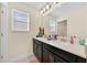 Bright bathroom featuring a double sink vanity with dark cabinets and a large mirror at 3853 Cortland Dr, Davenport, FL 33837