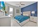 Cozy bedroom featuring a blue accent wall, a comfortable bed, and neutral-toned furnishings at 3853 Cortland Dr, Davenport, FL 33837