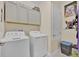 Functional laundry room equipped with a washer, dryer and overhead storage cabinets at 3853 Cortland Dr, Davenport, FL 33837