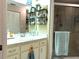 Well-lit bathroom with a vanity, mirrored cabinet, and glass-enclosed shower at 4007 Cypress Lndg S, Winter Haven, FL 33884