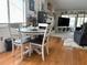 Charming dining area with wood floors and a table set for four, next to the living room and fireplace at 4007 Cypress Lndg S, Winter Haven, FL 33884