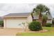Charming single-story home featuring a lush palm tree, manicured landscaping, and a two-car garage at 4007 Cypress Lndg S, Winter Haven, FL 33884