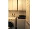 Laundry room with white cabinets and modern washer and dryer at 4007 Cypress Lndg S, Winter Haven, FL 33884