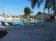 Community pool area with sun loungers, tables, and shade umbrellas at 4007 Cypress Lndg S, Winter Haven, FL 33884