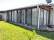 Sunroom with screened windows and sliding glass doors, and view of a green lawn at 4007 Cypress Lndg S, Winter Haven, FL 33884
