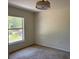 Neutral bedroom with a large window, ceiling fan, and plush carpeting at 403 Se 3Rd St, Fort Meade, FL 33841