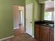 Kitchen with stainless steel sink, tile flooring, green paint, and an exterior door at 403 Se 3Rd St, Fort Meade, FL 33841