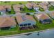 Backyard aerial view of a home featuring a lake view, solar panels, and well-kept landscaping at 4081 Dunmore Dr, Lake Wales, FL 33859