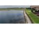 Scenic view of waterfront home featuring lush landscaping and a serene pond creates a picturesque and inviting outdoor living space at 4081 Dunmore Dr, Lake Wales, FL 33859