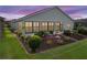 Backyard featuring a manicured lawn, garden beds with plants, and a scenic view with sunset at 4081 Dunmore Dr, Lake Wales, FL 33859