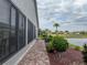 View of the home's backyard and waterside features a paver path, lush greenery, and serene waterfront scenery at 4081 Dunmore Dr, Lake Wales, FL 33859