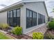 Rear exterior of the home showing screened windows, landscaping, and paved walkway provides an appealing outdoor view at 4081 Dunmore Dr, Lake Wales, FL 33859