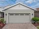 Garage exterior with a brick driveway and green garden at 4081 Dunmore Dr, Lake Wales, FL 33859