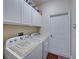 Laundry room featuring white cabinets, appliances and a white door at 4081 Dunmore Dr, Lake Wales, FL 33859