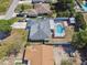 An aerial view of a house, highlighting the roof, screened-in pool, and surrounding landscape at 419 Broward Ter, Winter Haven, FL 33884