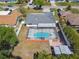 Birds eye view of a home with a screened in pool and patio, surrounded by mature landscaping at 419 Broward Ter, Winter Haven, FL 33884