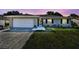 A single-story home with a white brick exterior, attached garage, and well-maintained lawn at 419 Broward Ter, Winter Haven, FL 33884