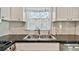 Modern kitchen featuring stainless steel sink, dark countertop, and white cabinets at 419 Broward Ter, Winter Haven, FL 33884