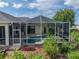 View of backyard with screened pool area and lush landscaping offers the perfect setting for relaxation and outdoor enjoyment at 428 Terranova St, Winter Haven, FL 33884