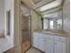 Well-lit bathroom boasts a tiled shower with glass door and white vanity with sink at 428 Terranova St, Winter Haven, FL 33884
