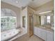 Large bathroom featuring a tub, shower, white vanity, and a large window at 428 Terranova St, Winter Haven, FL 33884