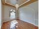 Dining area featuring hardwood floors, arched window, and elegant chandelier, creating an inviting ambiance for meals and gatherings at 428 Terranova St, Winter Haven, FL 33884