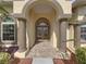 Elegant entrance showcasing a stone pathway, stately columns, and double doors with decorative glass accents at 428 Terranova St, Winter Haven, FL 33884