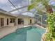 This refreshing screened pool features easy-access steps and is surrounded by lush landscaping and multiple access points to the home at 428 Terranova St, Winter Haven, FL 33884