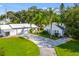 Aerial view showcasing a charming white home, spacious driveway, and lush green lawn at 4365 Canal Rd, Lake Wales, FL 33898