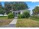 Charming single-story home with a screened porch, and mature landscaping on a sunny day at 4365 Canal Rd, Lake Wales, FL 33898