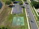 Aerial view of a community basketball court, playground, parking area, and palm tree-lined street at 4962 Sweet Cedar Cir, Orlando, FL 32829