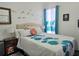 Serene bedroom with a queen-size bed adorned with floral-patterned bedding, bedside tables and lamps, and decorative wall accents at 4962 Sweet Cedar Cir, Orlando, FL 32829