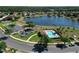 Aerial view of a community pool with a playground, parking area, and a serene lake at 4962 Sweet Cedar Cir, Orlando, FL 32829