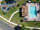 Overhead view of a community pool area with a playground, pool house, lounge chairs, and mature trees at 4962 Sweet Cedar Cir, Orlando, FL 32829