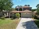 Charming two-story home featuring a well-manicured lawn, mature trees, and an attached two-car garage at 4962 Sweet Cedar Cir, Orlando, FL 32829