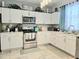 Well-lit kitchen with white cabinetry, modern appliances, and stylish decor at 4962 Sweet Cedar Cir, Orlando, FL 32829