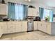 Spacious kitchen with white cabinets, stainless steel dishwasher, and modern tile floor at 4962 Sweet Cedar Cir, Orlando, FL 32829